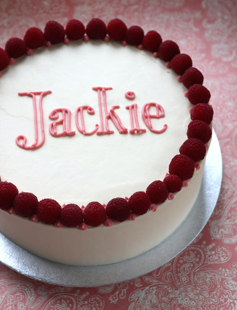 Two layers of gluten free, dairy free Chocolate & Olive Oil Cake, filled & frosted with Madagascar vanilla Swiss meringue buttercream and decorated with fresh raspberries. All ingredients gluten-free