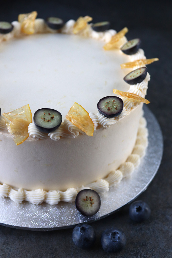 Gluten free, dairy free lemon and olive oil cake. Two layers of delicate sponge, filled and frosted with dairy-free lemon buttercream. This cake is decorated with piped buttercream, candied lemon and fresh blueberries. All ingredients glutenfree and dairyfree