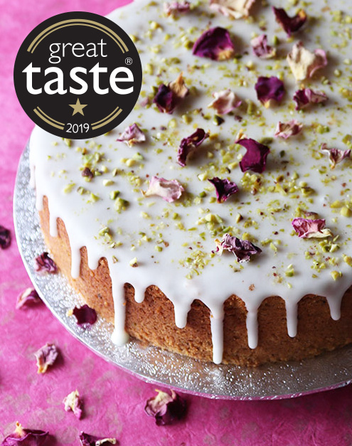 For Mothers' Day, a gluten free Lemon & Pistachio Cake, made with organic lemons, pistachios & almonds and topped with lemon glacé frosting and organic rose petals. A Great Taste award winner, all ingredients gluten-free. With label for your message. Delivered by post for Mothers' Day. Delivery and collection also available in London