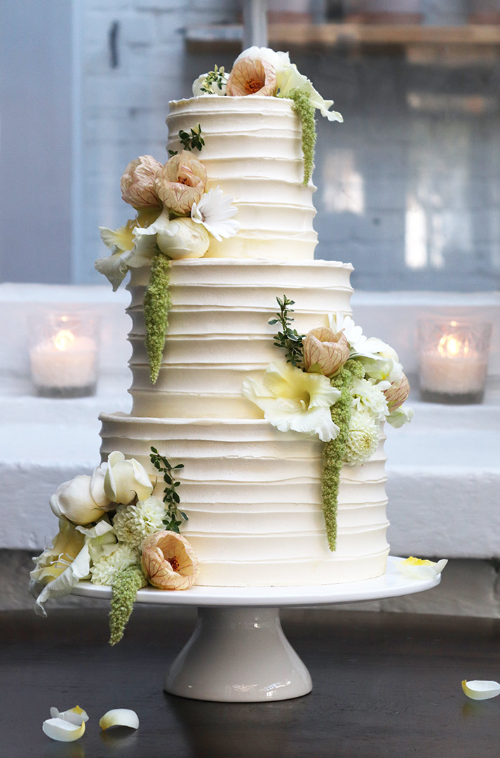A 3-tier October wedding cake. Gluten-free white chocolate & passionfruit. Decorated with organic, edible flowers. All ingredients organic and gluten free. Price includes tasting consultation, and delivery & assembly at your London venue