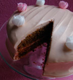 Gluten-free, lactose-free Pink Passion Cake, made with organic chopped, roasted hazelnuts and freshly grated beetroot and spiced with nutmeg, cinnamon and ginger. With a lactose-free cream cheese frosting and finished with rice-paper roses. Gluten free and lactose free. Delivery in London