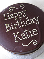 Gluten-free chocolate and nut cake made with organic ground almonds and organic Fairtrade dark chocolate. Covered with organic Fairtrade dark chocolate ganache and decorated with piped birthday message in organic white chocolate. Available diary free 