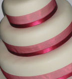 A fabulous gluten-free, wheat-free 3 tier wedding cake. Top tier: moist ginger cake, gluten free and dairy free. Middle tier gluten-free and dairy-free orange and almond cake. Bottom tier glutenfree chocolate and hazelnut cake. All cakes are gluten-free and wheat-free, made with organic ingredients. Topped with organic marzipan and smooth ivory icing, and decorated with silk ribbons: the perfect centrepiece for your gluten-free wedding