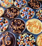 Rich chocolate cupcakes for a gluten-free teenage birthday. Made with organic Fairtrade dark and white chocolate and ground almonds. Topped with dark chocolate and white chocolate ganache and decorated with gluten free sprinkles. Delivery available in London. These cupcakes can be posted. All ingredients gluten free