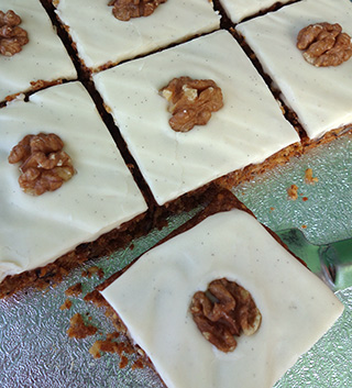 Gluten free vegan carrot cake squares, made with organic carrot and coconut, crushed pineapple and chopped walnuts, and spiced with cinnamon, Jamaica allspice, ginger and Madagascar vanilla seeds. With creamy soya/vanilla seed frosting. All ingredients glutenfree, eggfree and dairyfree, no animal products