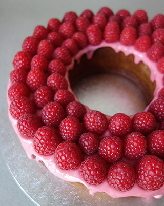 Raspberry & Almond Cake with raspberry glacé icing, topped with masses of fresh organic raspberries. All ingredients organic, glutenfree, dairyfree & flourfree