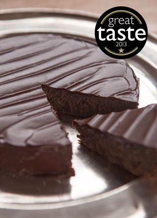 Award-winning gluten free rich chocolate cake made with gluten free ingredients: organic ground almonds and dark chocolate, and Kingston 62 Jamaica rum. Covered with dark chocolate ganache. All ingredients gluten-free. This cake won a Great Taste award in 2013, and a Bronze medal at the FreeFrom Food Awards 2017. Also available diary free
