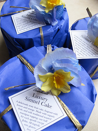 Gluten-free Simnel Cakes for Easter, made with organic fruit steamed in apple juice, with a splash of almond extract. Traditional marzipan topping, all ingredients gluten free. Milk free also available. Sustainably packaged in pretty tissue, for delivery by post in the UK. Hand delivery also available in London