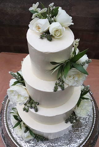 4-tier gluten-free wedding cake at Horniman Conservatory: Two tiers of layered Orange & Almond, a layered Chocolate & Olive Oil Cake, and Lemon Elderflower at the bottom. All covered with vanilla Swiss meringue buttercream. Gprgepus edible flowers from Maddocks Farm Organics. All ingredients gluten free