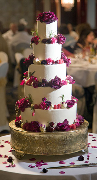 Glutenfree wedding: a fabulous gluten-free, wheat-free wedding cake. 3 tiers of award-winning, dairyfree Tunisian Orange & Almond Cake, and 2 tiers of dairy-free Chocolate & Olive Oil Cake. Filled and frosted with white chocolate Swiss meringue buttercream, and decorated with organic edible flowers and chocolate truffles. All ingredients gluten free. Price includes tasting consultation, and delivery and assembly at your London venue. Organic edible flowers and foliage from maddocksfarmorganics.co.uk