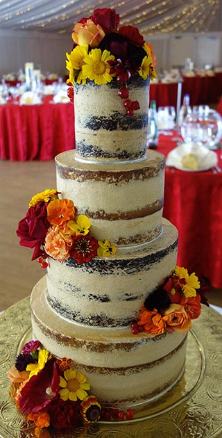 4-tier gluten-free vegan wedding cake. Two tiers of gluten free vegan Orange & Almond Cake, and two tiers of glutenfree vegan Dark Chocolate Cake, made with raw virgin coconut oil. All made with organic palm sugar, no refined sugars. Filled and frosted with vegan buttercream. Decorated with redcurrants, and organic edible flowers from maddocksfarmorganics.co.uk. For a Hindu wedding at Fennes, Essex