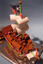 glutenfree pirate ship cake made with organic fairtrade chocolate sponge and covered in organic chocolate ganache, decorated with gluten-free chocolate beans. Delivered to Kennington, London