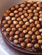 gluten-free chocolate and hazelnut cake made with organic ingredients: torta alla gianduja, made with organic Fairtrade dark chocolate & ground hazelnuts and hazelnut liqueur. Covered with dark chocolate ganache and roasted hazelnuts