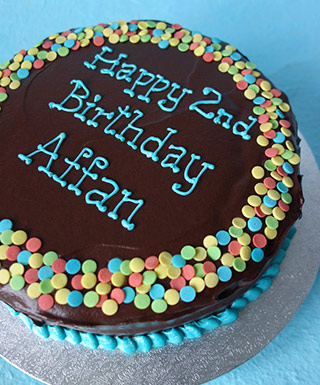 Gluten free, lactose free Mocha Chocolate Cake with ganache frosting, piped message and sprinkles